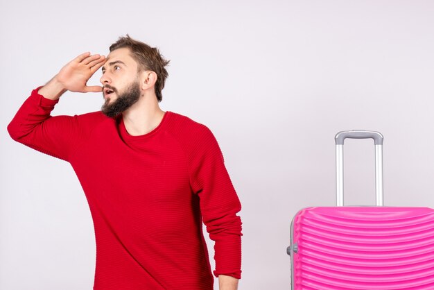 Vue de face jeune homme avec sac rose sur mur blanc voyage photo couleur humaine vacances vol voyage été