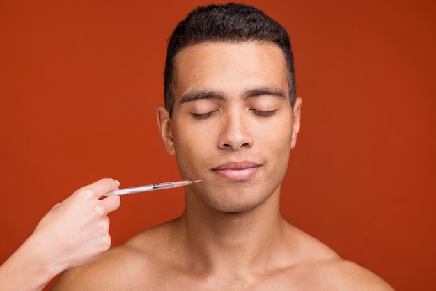 Vue de face jeune homme et seringue