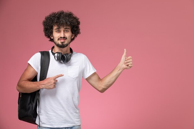 Vue de face jeune homme soulignant son geste de pouce en l'air