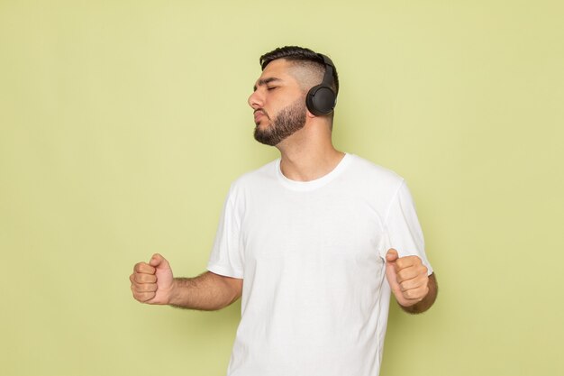 Une vue de face jeune homme en t-shirt blanc, écouter de la musique