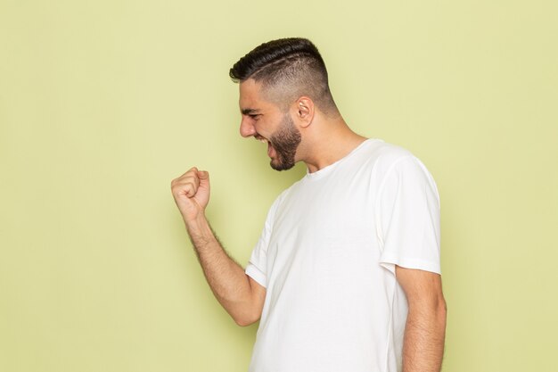 Une vue de face jeune homme en t-shirt blanc avec une expression ravie