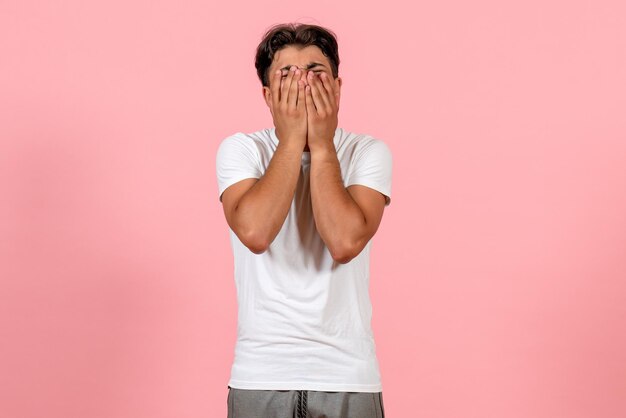 Vue de face jeune homme en t-shirt blanc sur fond rose