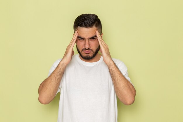 Une vue de face jeune homme en t-shirt blanc pensant