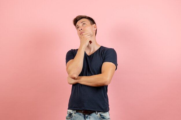 Vue de face jeune homme en t-shirt bleu pensant sur fond rose modèle de couleur d'émotion humaine masculine