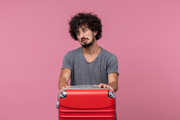 Vue de face jeune homme en t-shirt gris se préparant pour un voyage sur l'espace rose