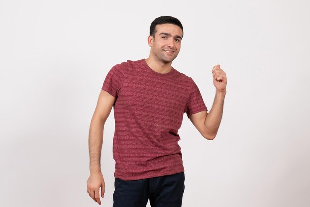 Vue de face jeune homme en t-shirt rouge foncé posant sur fond blanc