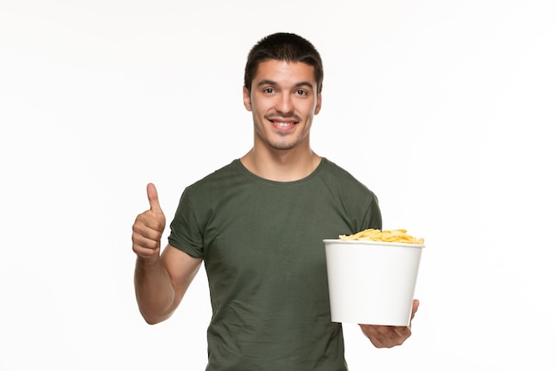 Vue De Face Jeune Homme En T-shirt Vert Tenant Le Panier Avec Des Cips De Pommes De Terre Sur Fond Blanc Cinéma Film Plaisir Solitaire