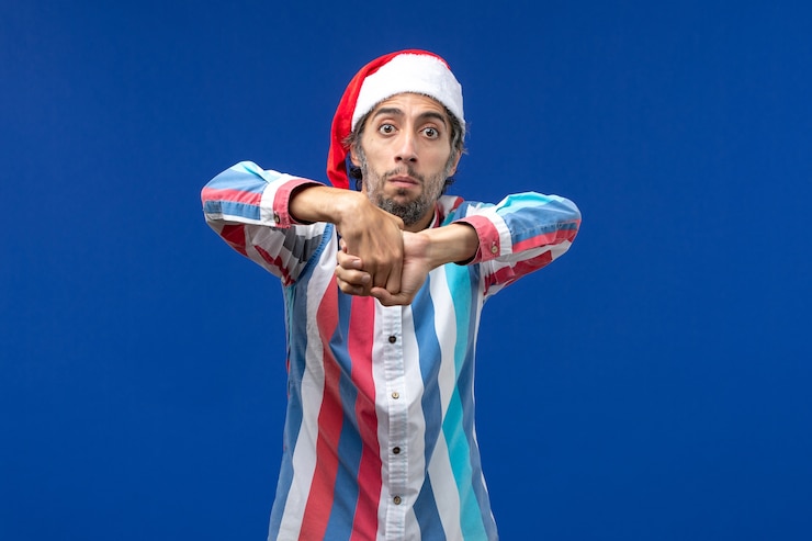 Photo gratuit vue de face jeune homme touchant ses mains, émotion noël mâle