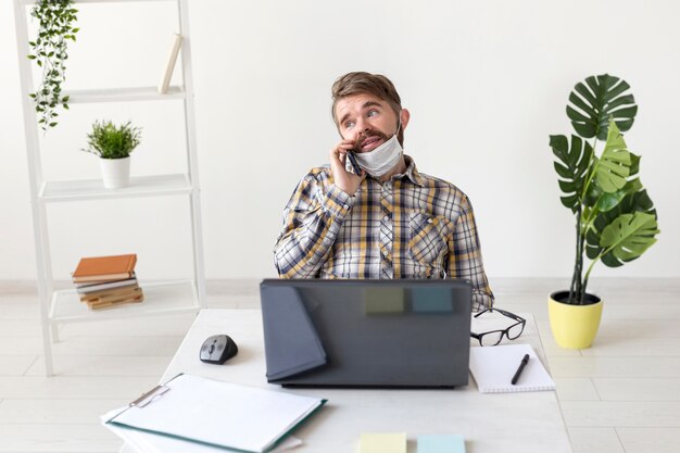 Vue de face jeune homme travaillant à domicile