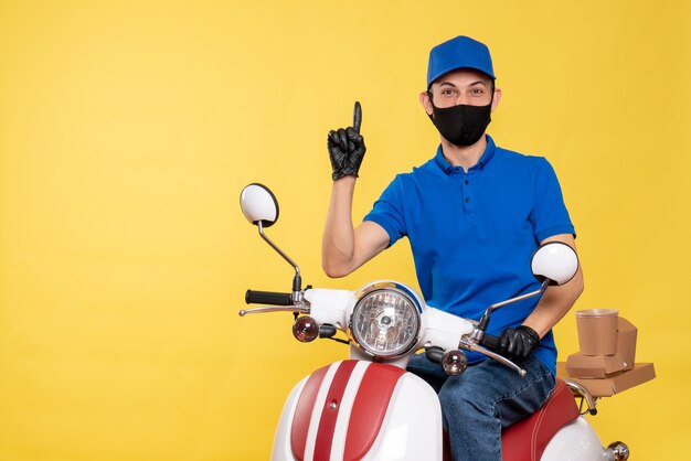 Vue de face jeune homme en uniforme bleu et masque sur fond jaune