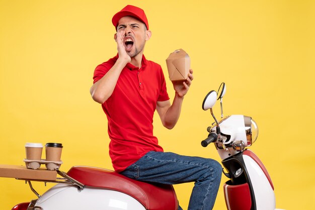 Vue de face jeune homme en uniforme rouge appelant fort sur fond jaune