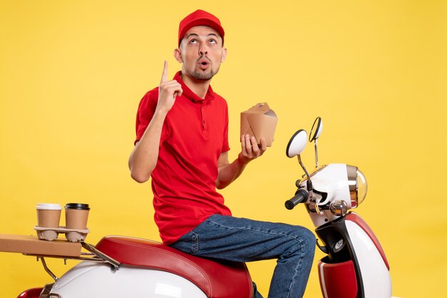 Vue de face jeune homme en uniforme rouge sur fond jaune