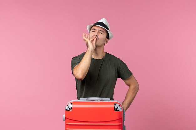 Vue de face jeune homme en vacances portant un chapeau sur l'espace rose