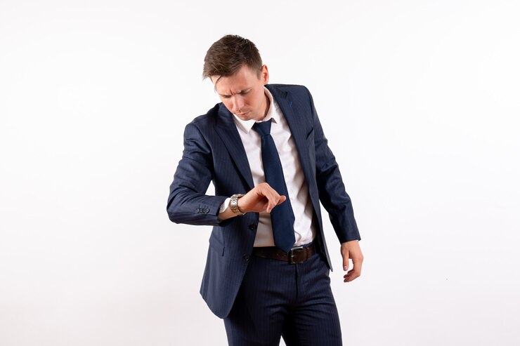 Photo gratuit vue de face jeune homme vérifier l'heure en costume classique sur fond blanc costume d'émotion mannequin homme humain