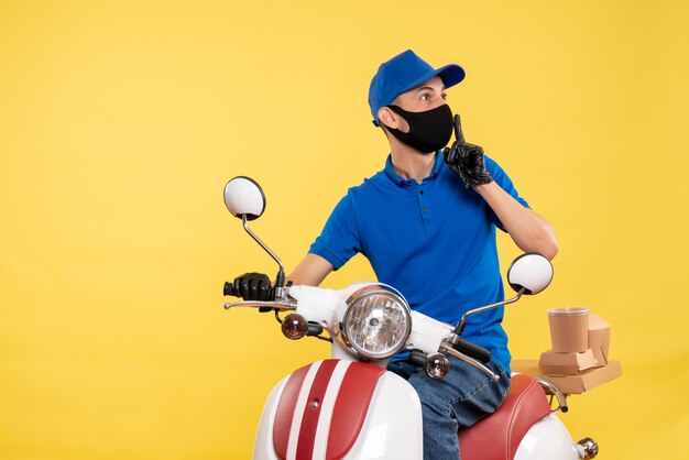 Vue de face jeune messager en uniforme bleu sur fond jaune