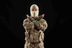 Photo gratuite vue de face jeune soldat en uniforme sur le mur noir