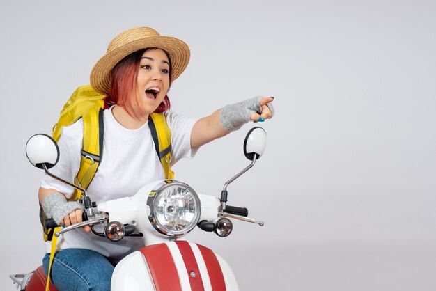 Vue de face jeune touriste assis sur une moto sur mur blanc véhicule femme touriste vitesse touriste