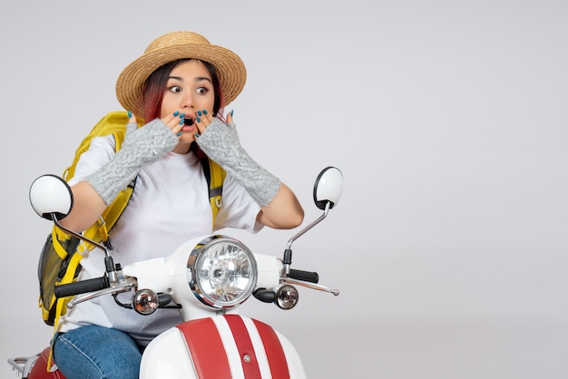 Vue de face jeune touriste assis sur la moto sur le mur blanc vitesse femme véhicule photo tour touriste