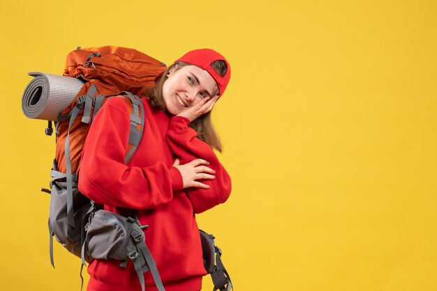 Vue de face jeune touriste avec sac à dos et bonnet rouge souriant