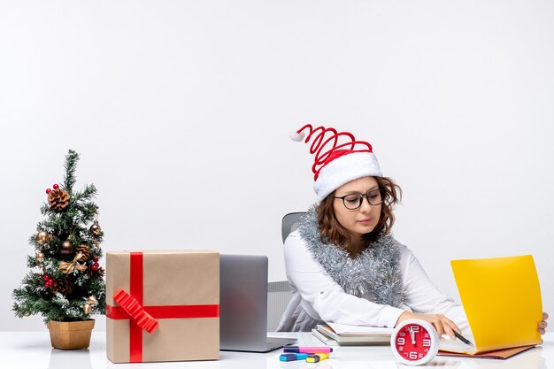 Vue de face jeune travailleuse au lieu de travail, écrire des notes sur fond blanc