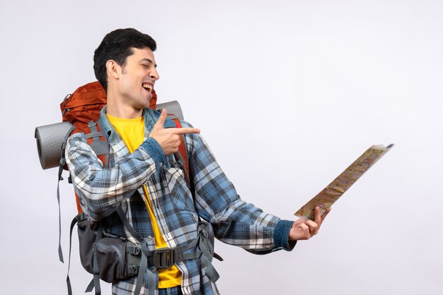 Vue de face jeune voyageur avec sac à dos pointant à l'endroit sur la carte