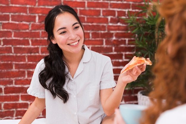 Vue de face de jeunes amis partageant une pizza