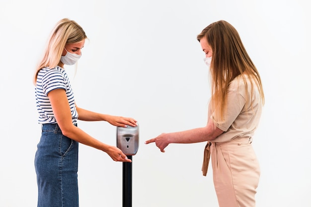 Photo gratuite vue de face jeunes femmes désinfectant les mains