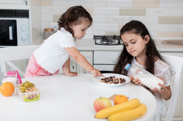 Vue de face des jeunes frères et sœurs prenant son petit déjeuner