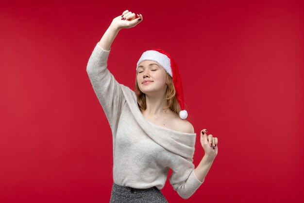 Vue de face d'une jolie femme essayant de danser sur le rouge