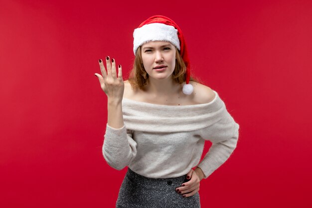 Vue de face d'une jolie femme avec une expression confuse sur le rouge