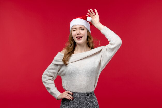 Vue de face d'une jolie femme jouant avec une casquette rouge sur rouge