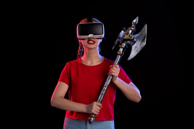 Vue de face d'une jolie femme jouant à la réalité virtuelle dans l'obscurité