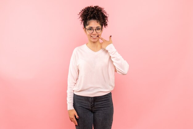 Vue de face de jolie femme souriante sur rose