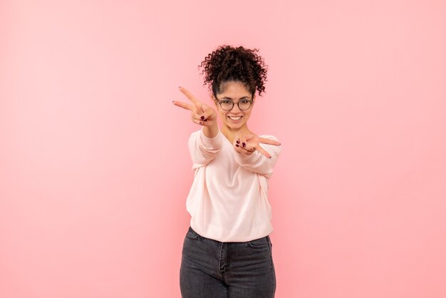 Vue de face de jolie femme souriante sur rose