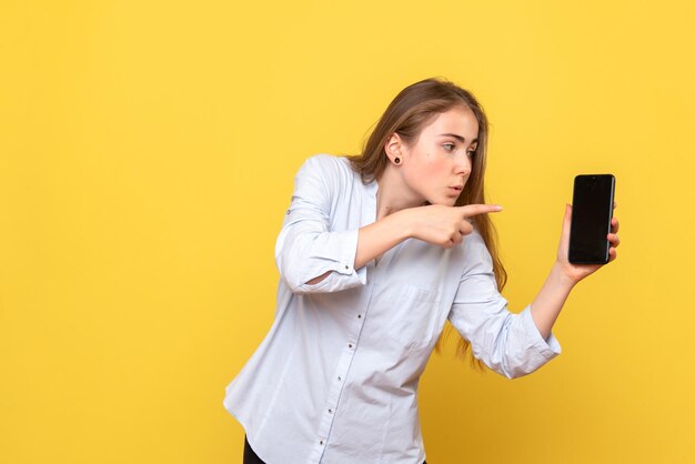 Vue de face d'une jolie femme tenant un téléphone