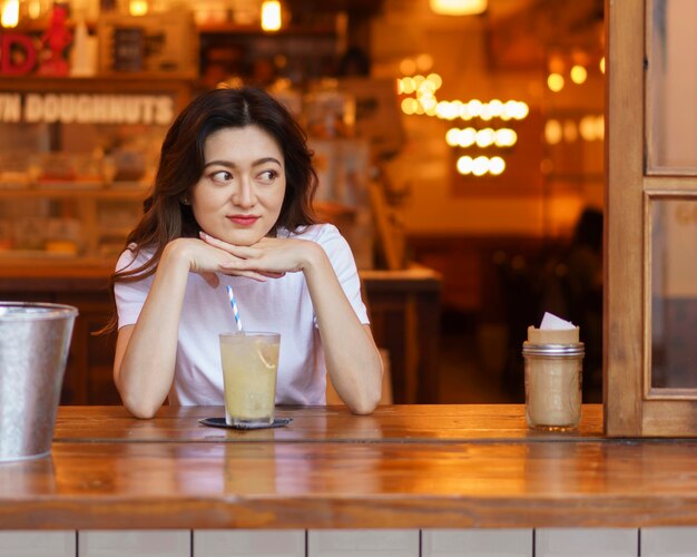 Vue de face de jolie fille japonaise buvant de la limonade