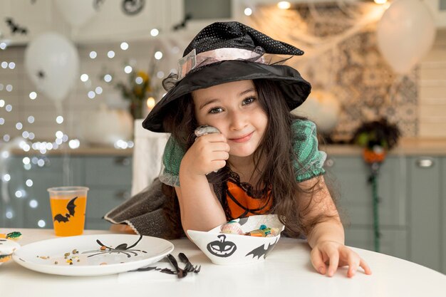 Vue de face de la jolie petite fille avec costume de sorcière