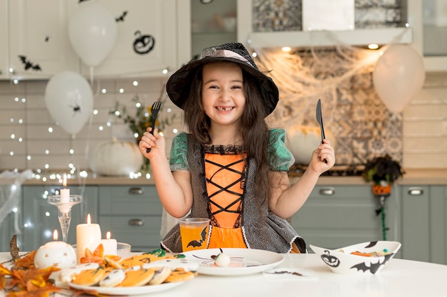 Vue de face de la jolie petite fille avec costume de sorcière