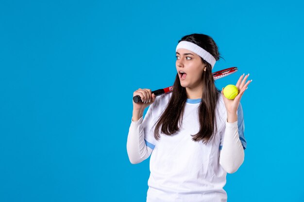Vue de face de la joueuse de tennis tenant une raquette de tennis et une balle
