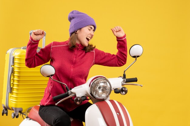 Vue de face joyeuse jeune femme sur cyclomoteur