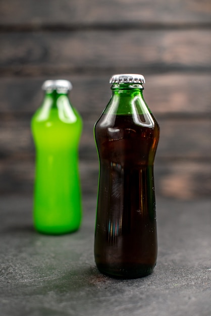Photo gratuite vue de face jus noirs et verts en bouteilles