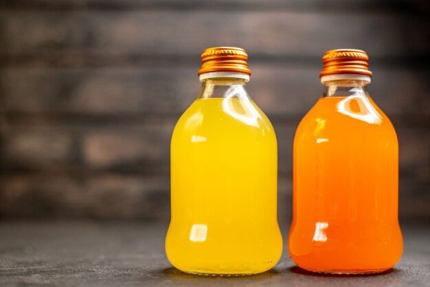 Vue de face jus orange et jaune en bouteilles