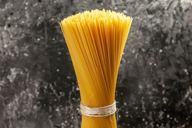 Vue de face de longues pâtes italiennes crues sur le repas photo de cuisine de pâte de couleur alimentaire gris clair