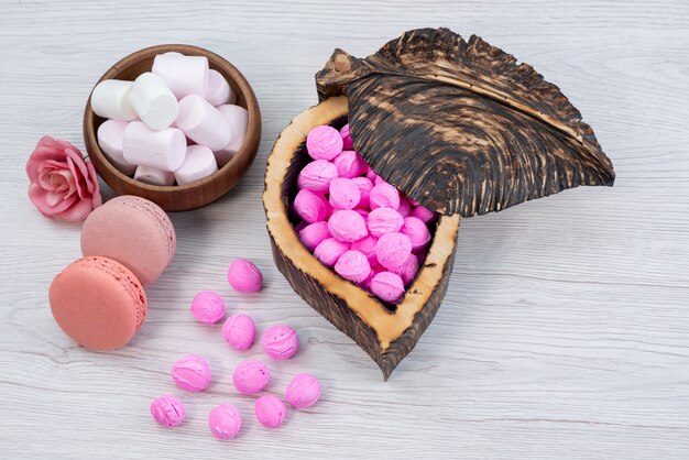 Une vue de face macarons français avec des guimauves et rose, bonbons sur blanc, bonbon biscuit au sucre sucré