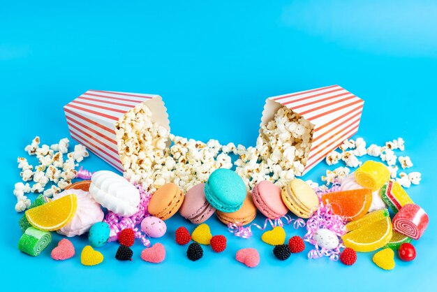 Une vue de face macarons français avec marmelades pop-corn guimauve sur bleu