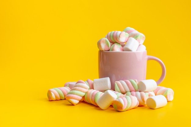 Une vue de face à mâcher des marmelades à l'intérieur et à l'extérieur rose, tasse sur confiture de couleur sucre jaune, sucré