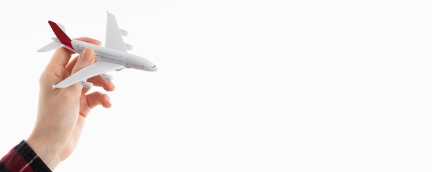 Vue de face de la main tenant la figurine d'avion avec espace copie