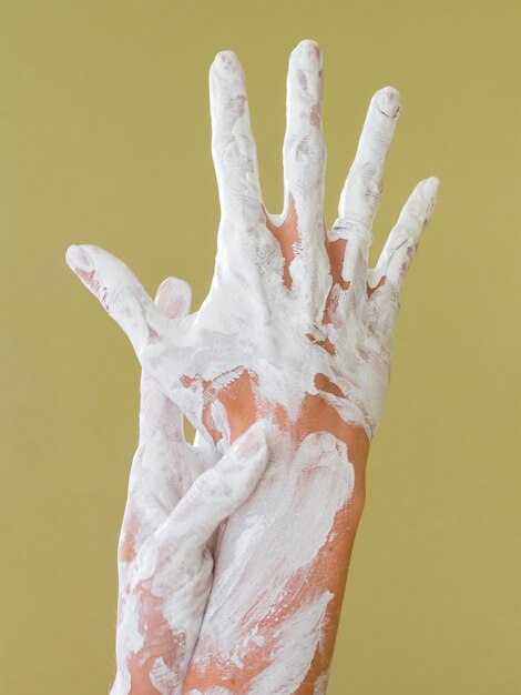 Vue de face des mains peintes avec de la peinture blanche