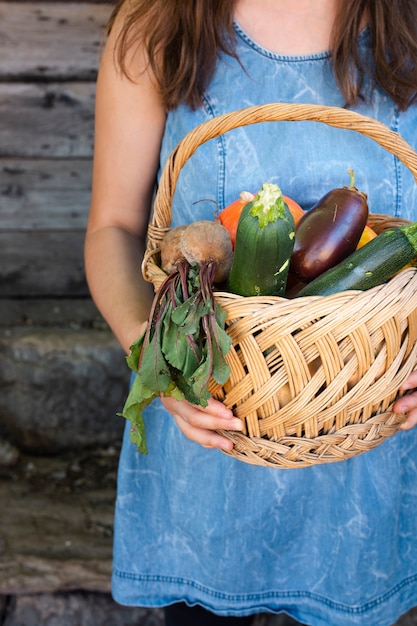 Vue de face des mains tenant un panier de légumes