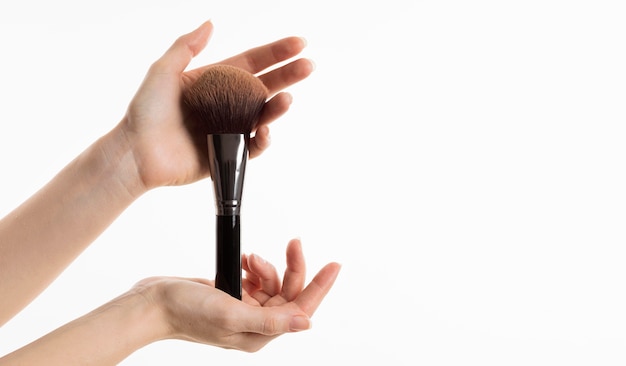 Photo gratuite vue de face des mains tenant un pinceau de maquillage